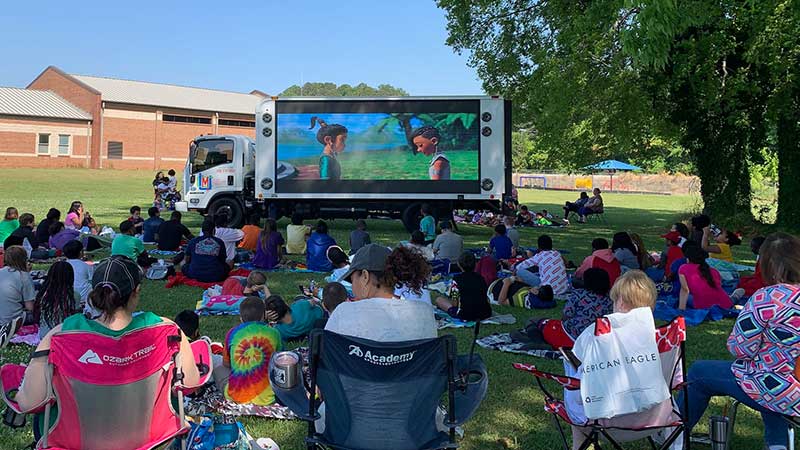 A group of families enjoying amovie on our digital billboard truck in Anniston, AL